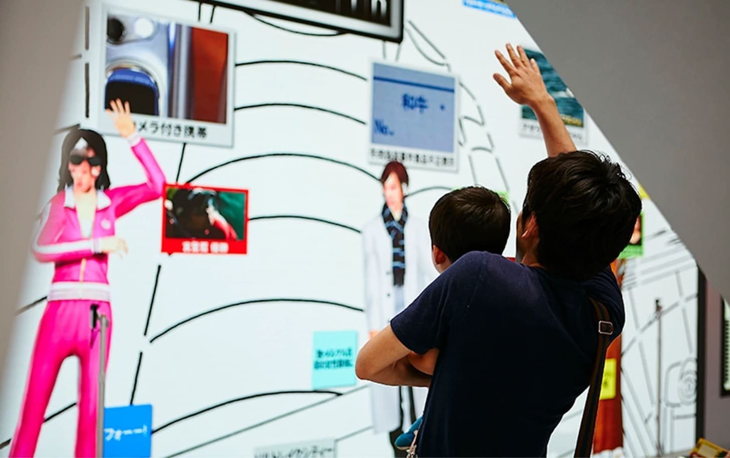 Visitors seen from behind, reaching toward the wall visuals